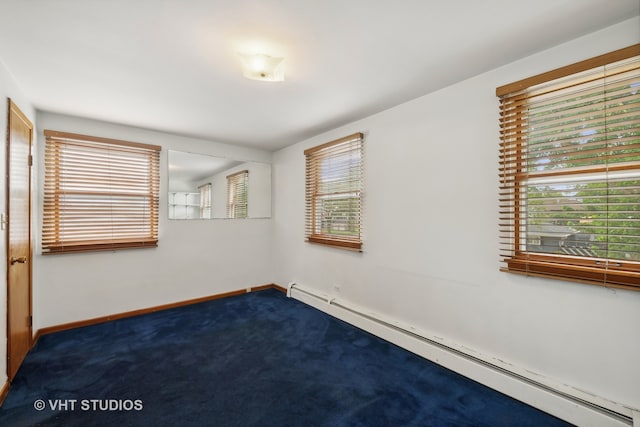 carpeted spare room featuring baseboard heating