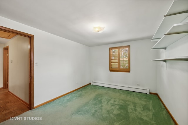 spare room featuring a baseboard heating unit and carpet flooring