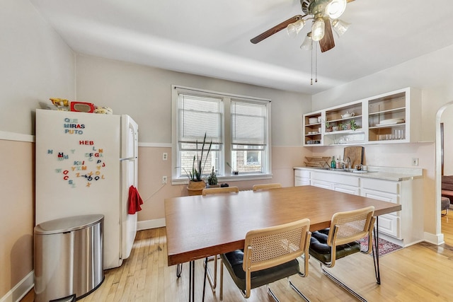 dining space with light wood-type flooring, ceiling fan, and sink