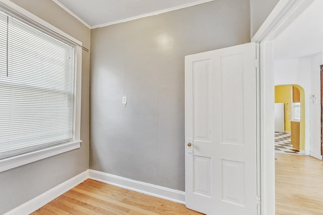 empty room featuring crown molding and wood-type flooring