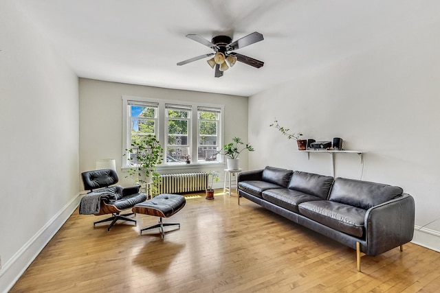 living room featuring light wood-type flooring, radiator, and ceiling fan