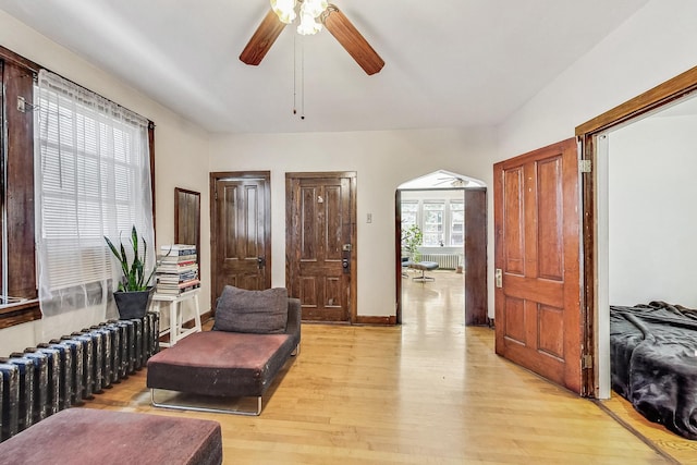 living area featuring light wood-type flooring, radiator, and ceiling fan