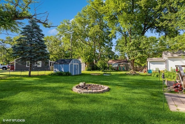 view of yard featuring a fire pit and a storage shed