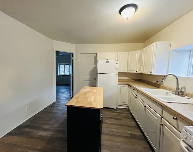 kitchen featuring wood counters, white refrigerator, white cabinets, and sink