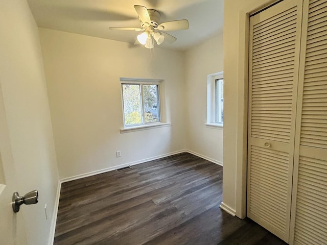 unfurnished bedroom featuring ceiling fan, a closet, and dark wood-type flooring