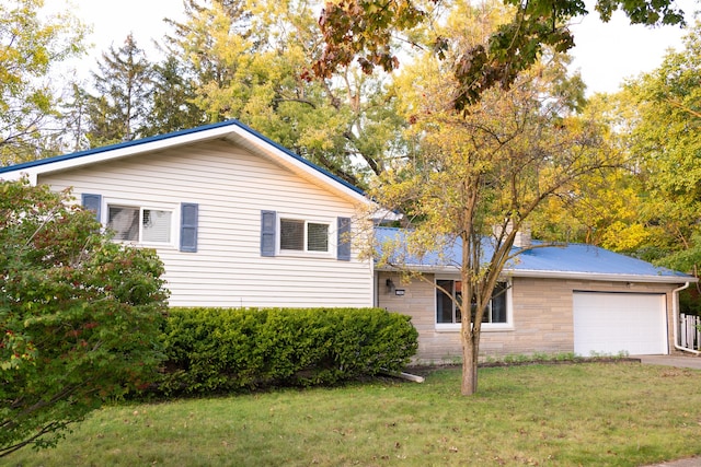 view of side of home featuring a garage and a lawn