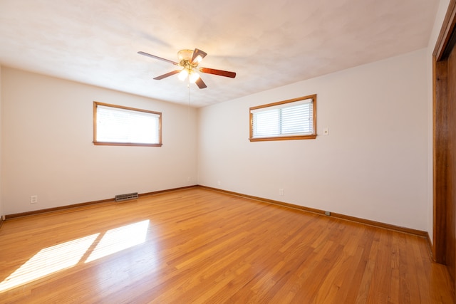 empty room with light hardwood / wood-style floors, ceiling fan, and a wealth of natural light