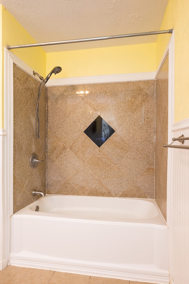 bathroom with tile patterned floors, a textured ceiling, and tiled shower / bath