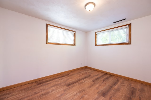 unfurnished room with hardwood / wood-style flooring and plenty of natural light