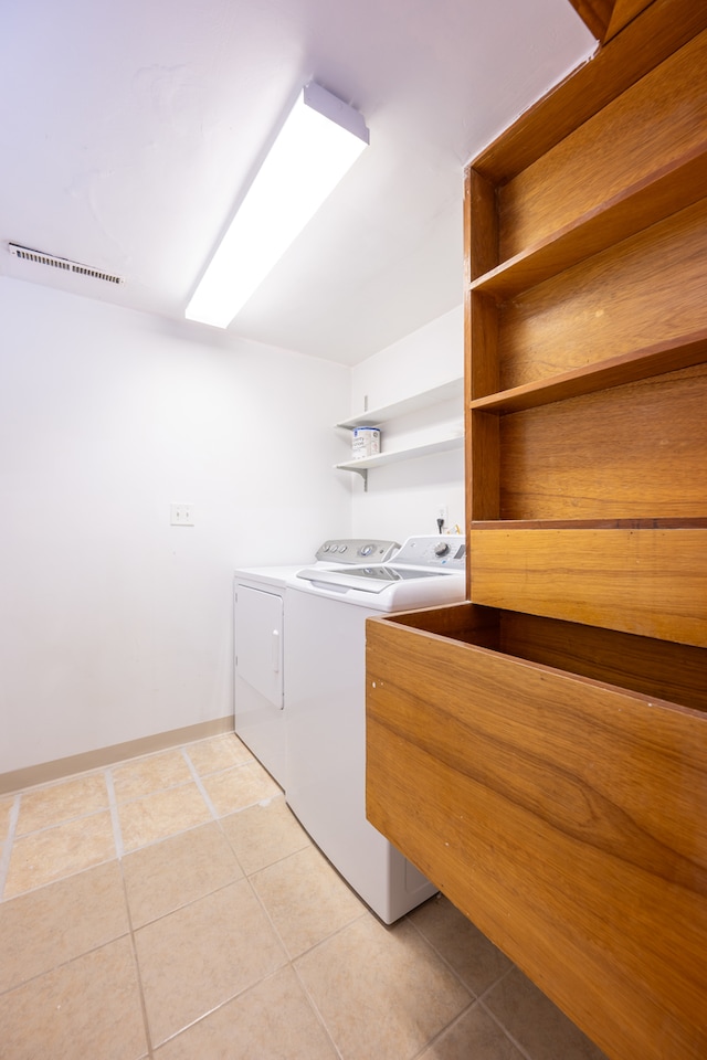 laundry area featuring washing machine and dryer and light tile patterned floors