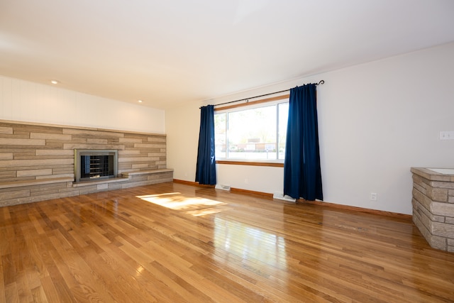 unfurnished living room featuring light hardwood / wood-style flooring and a fireplace