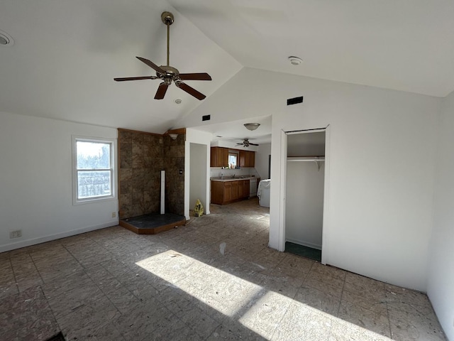 unfurnished living room featuring sink and high vaulted ceiling