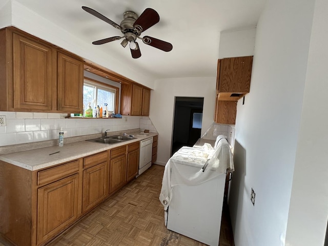 kitchen featuring sink, ceiling fan, white dishwasher, decorative backsplash, and light parquet flooring