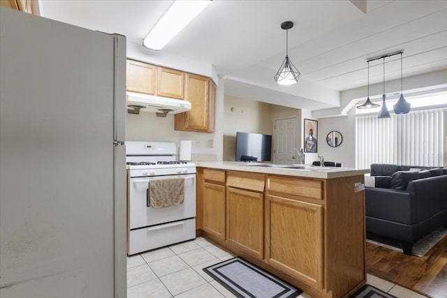 kitchen with hanging light fixtures, light tile flooring, kitchen peninsula, and white appliances