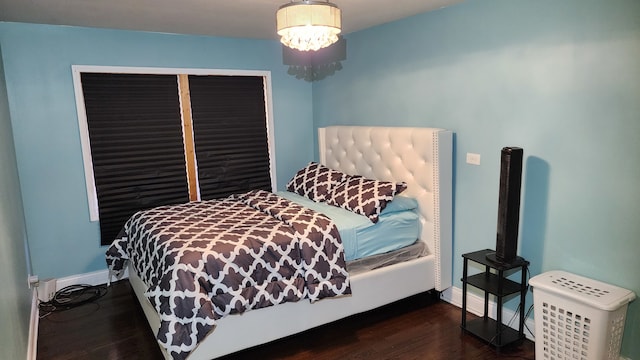 bedroom with a chandelier and dark hardwood / wood-style flooring