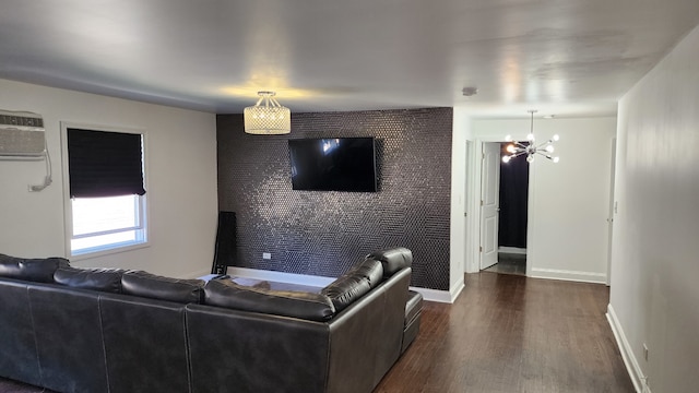 living room with a notable chandelier, dark wood-type flooring, and a wall mounted air conditioner