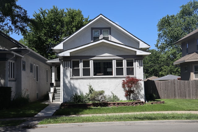 bungalow-style house with a front lawn