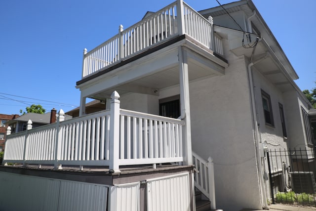 view of side of property with a balcony and central air condition unit