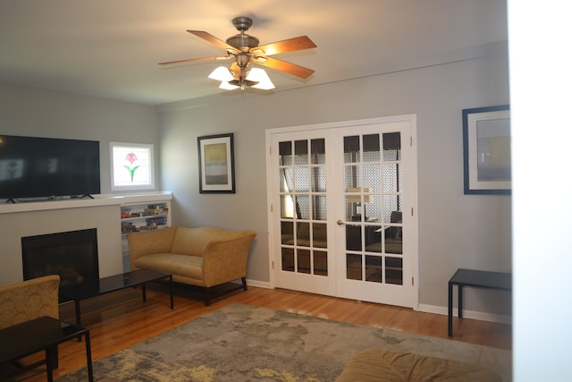 living area with hardwood / wood-style flooring, ceiling fan, and french doors