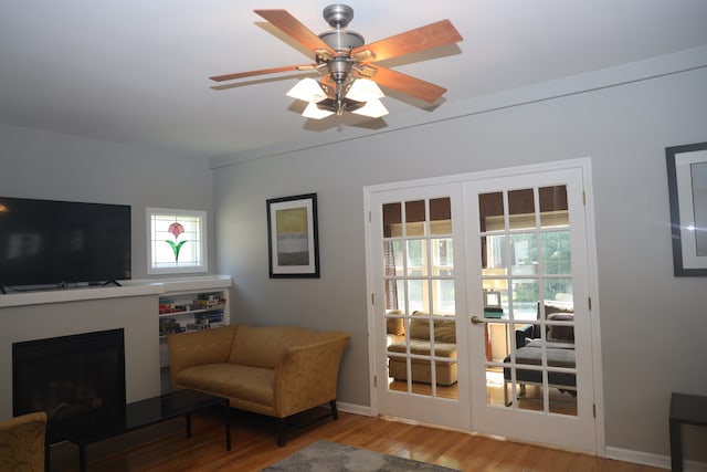 living area featuring ceiling fan, a healthy amount of sunlight, french doors, and wood-type flooring