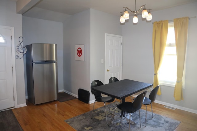 1040 N Austin Blvd, Oak Park, IL 60302 - dining space featuring baseboards, wood finished floors, visible vents, and a chandelier