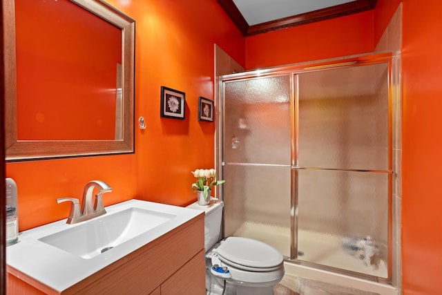 bathroom featuring toilet, a shower with door, vanity, and crown molding