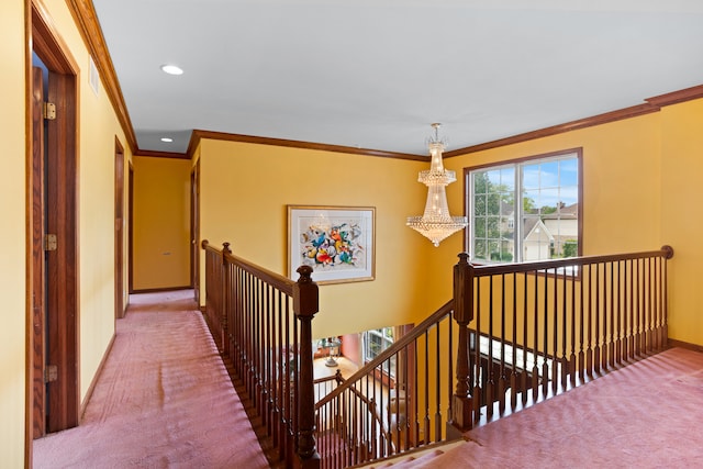 hall with a notable chandelier, ornamental molding, and carpet flooring