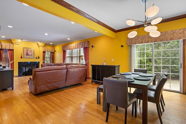 dining space featuring light hardwood / wood-style floors, crown molding, beamed ceiling, and ornate columns