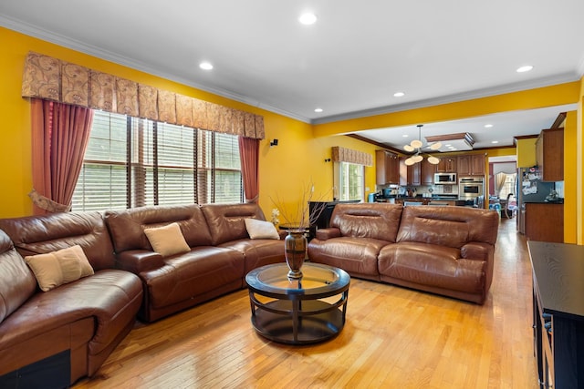 living room with ceiling fan, crown molding, and light hardwood / wood-style flooring