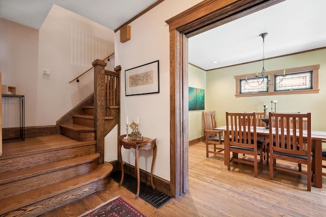 interior space featuring light hardwood / wood-style floors, crown molding, and a chandelier