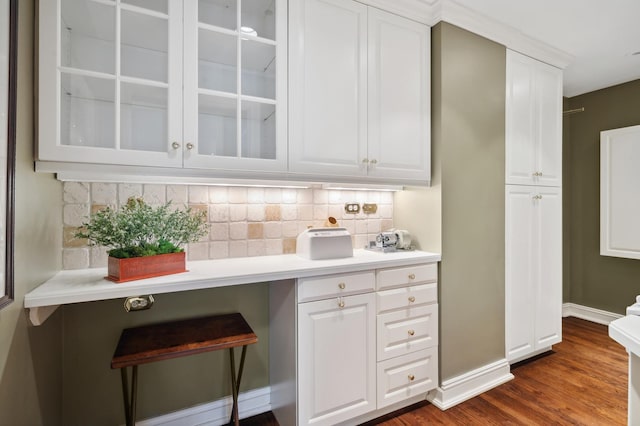 bar with backsplash, baseboards, and dark wood-type flooring