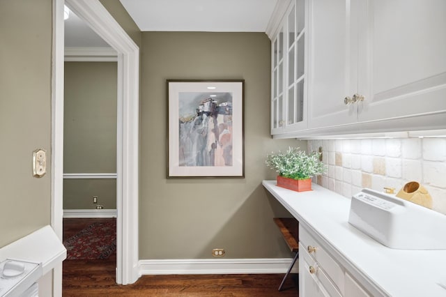interior space with baseboards, tasteful backsplash, and dark wood-style floors