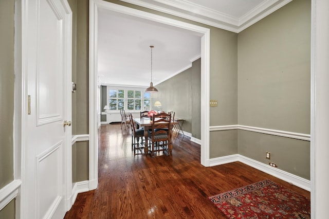 dining space with baseboards, ornamental molding, and dark wood finished floors