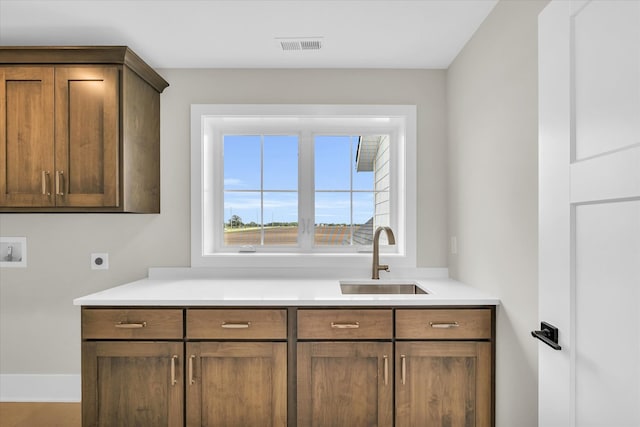 interior space featuring sink, washer hookup, cabinets, and hookup for an electric dryer