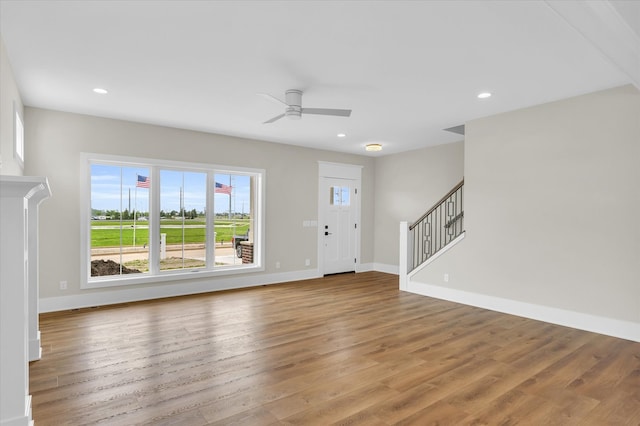 unfurnished living room with wood-type flooring and ceiling fan