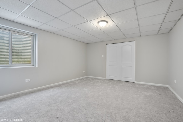 carpeted empty room featuring a paneled ceiling