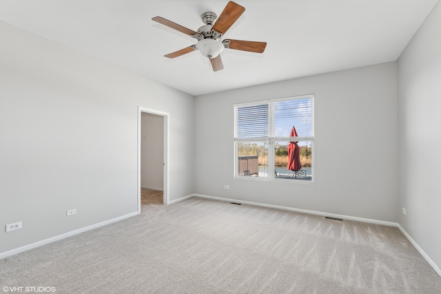 empty room featuring ceiling fan and light carpet