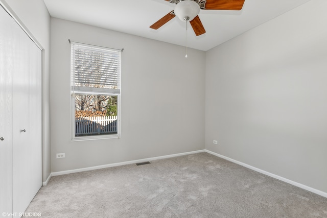 carpeted spare room featuring ceiling fan