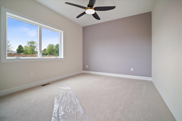 spare room with light colored carpet and ceiling fan