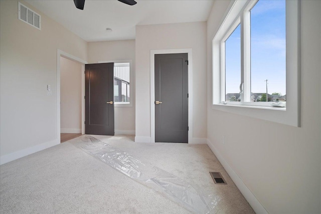 unfurnished bedroom with light carpet and ceiling fan