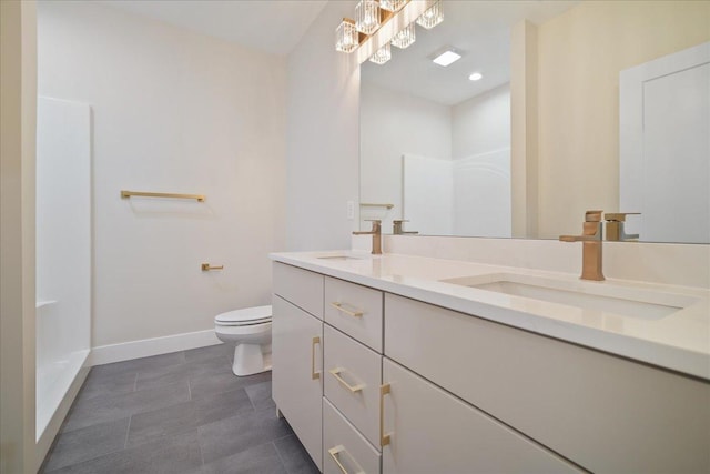 bathroom with walk in shower, vanity, and toilet