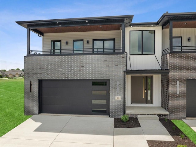 contemporary home with a garage, a front lawn, and a balcony