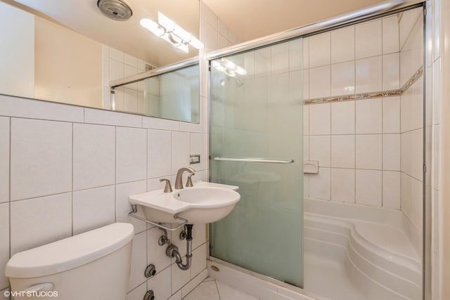 bathroom with backsplash, tiled shower, tile walls, and toilet