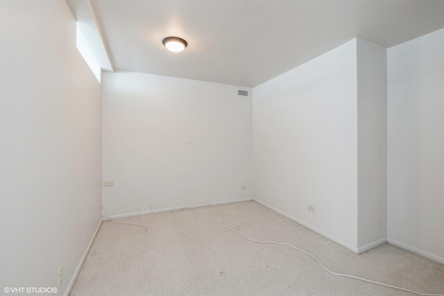 unfurnished room featuring light carpet, visible vents, and baseboards