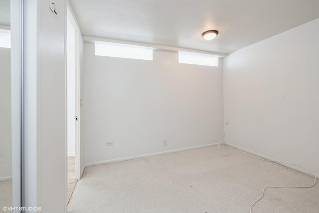 below grade area with light colored carpet and baseboards