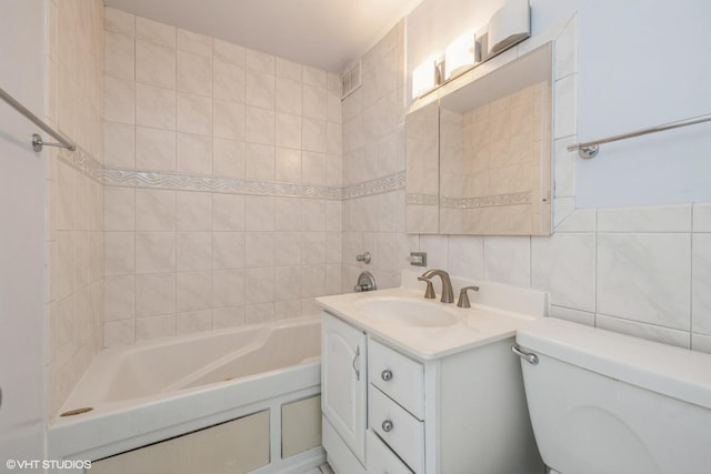 full bathroom with toilet, vanity, and tile walls