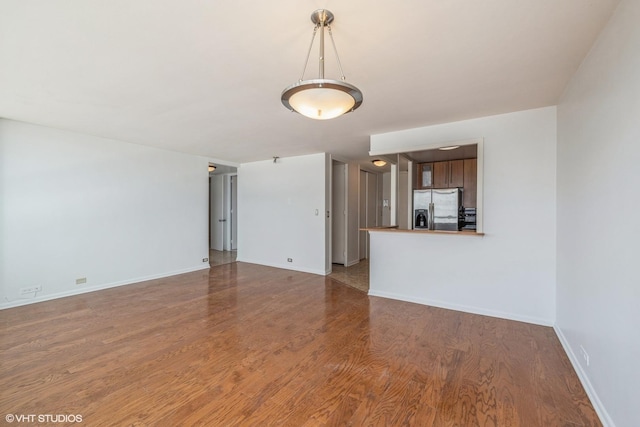 unfurnished living room with baseboards and wood finished floors