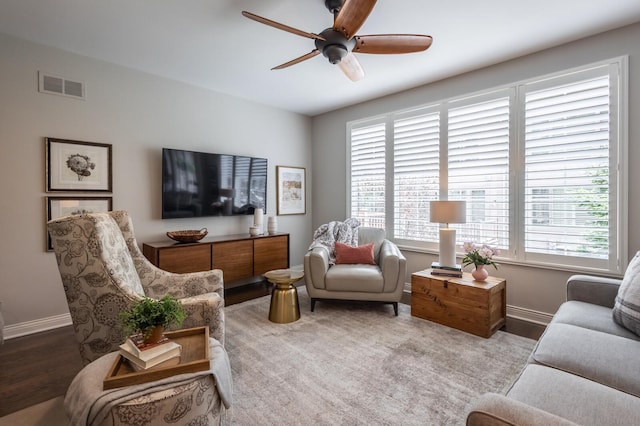 living room featuring wood-type flooring and ceiling fan