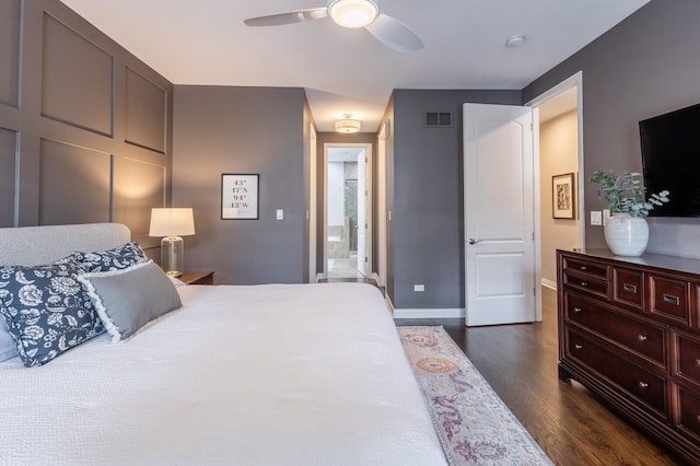 bedroom with dark hardwood / wood-style floors, ceiling fan, and ensuite bath