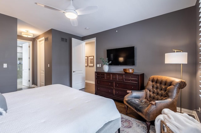 bedroom featuring ensuite bath, ceiling fan, and hardwood / wood-style flooring